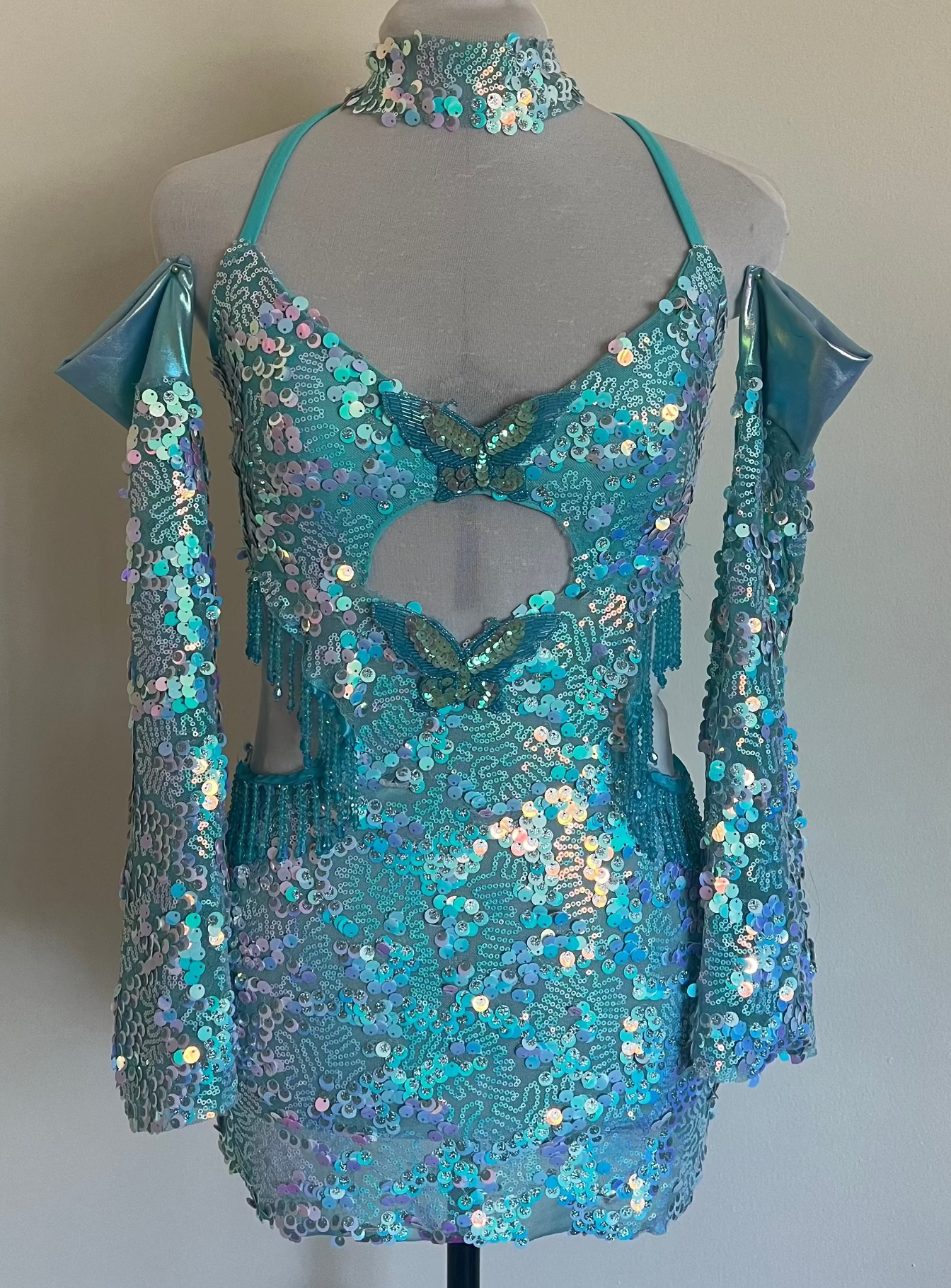 Turquoise sequin dress on a mannequin against a plain background