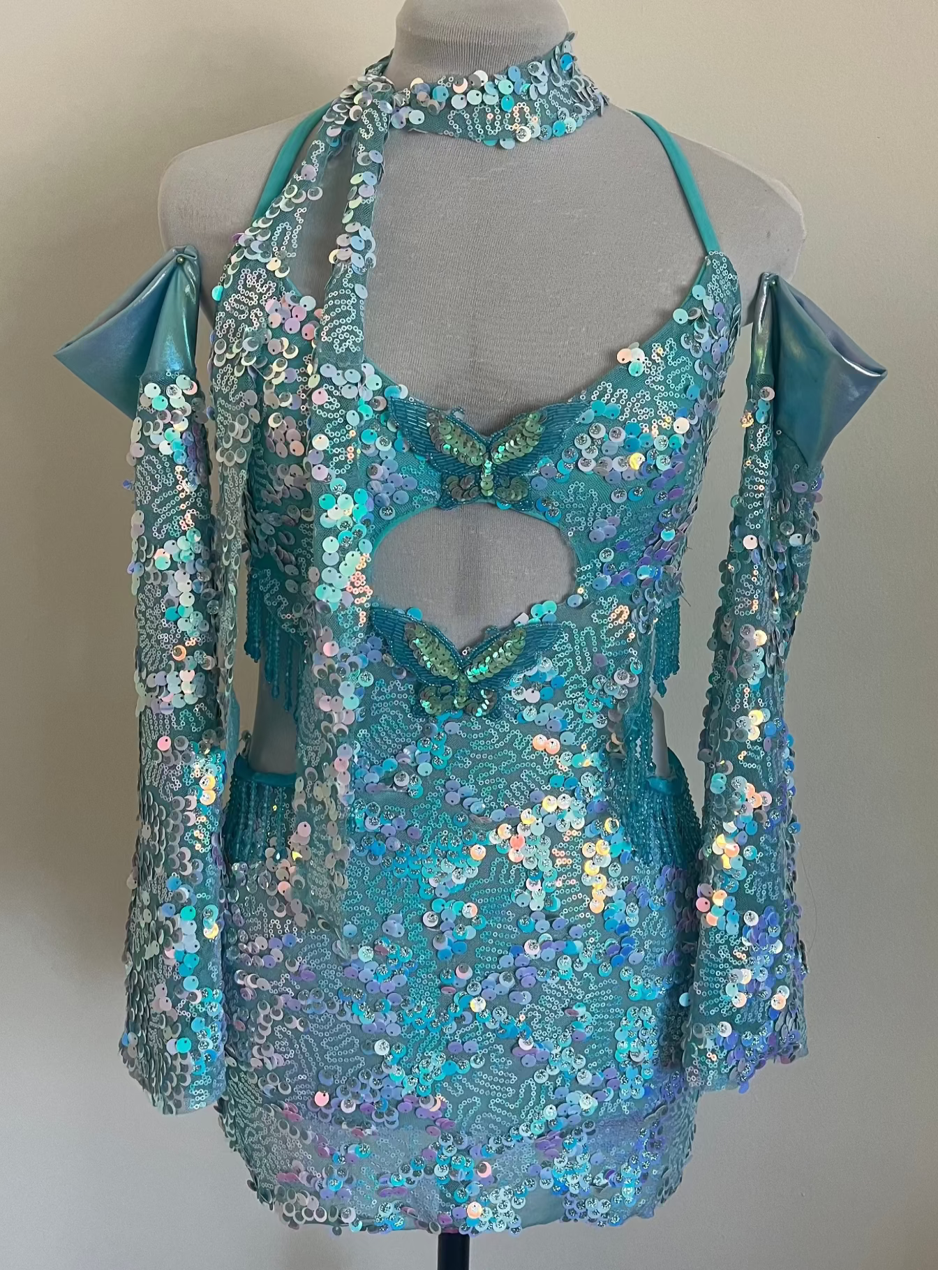 Turquoise sequin dress on a mannequin against a plain background