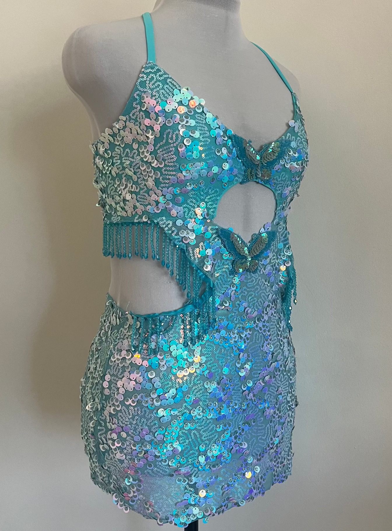 Turquoise sequin dress on a mannequin against a plain background